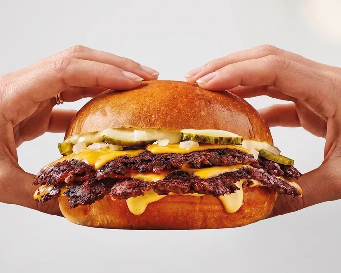 Un smash burger Starsmash tenu à deux mains